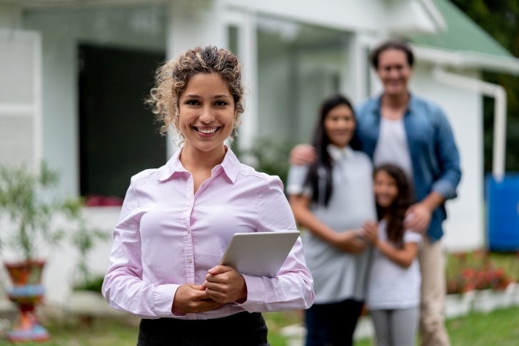 real estate agent and a family in front of the house