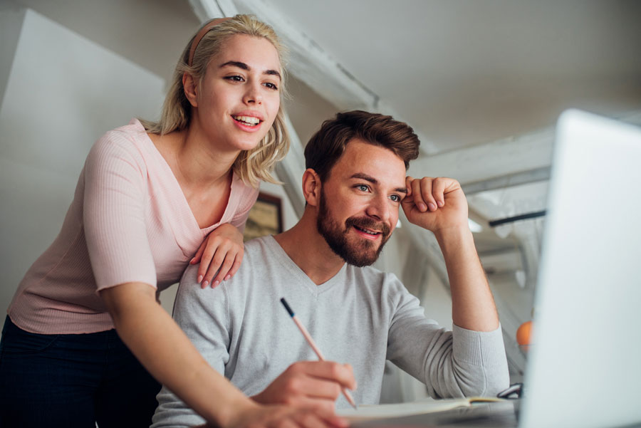 a young couple writing a winning offer letter to buy a house