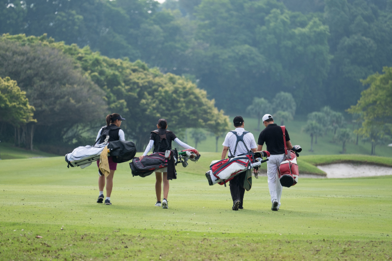 Friends walk together down the fairway