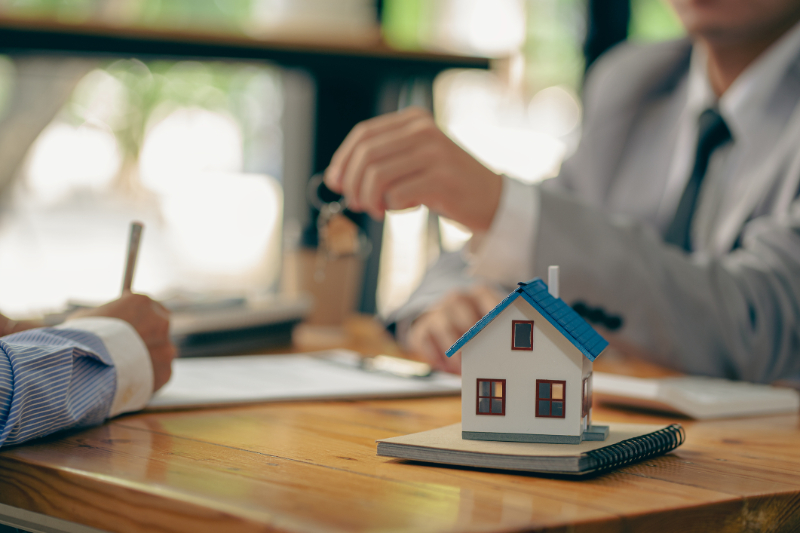 Sales representatives hand out the house keys to customers after signing a contract